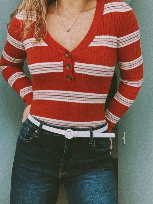 Suéter rojo con rayas blancas y tres botones en el pecho