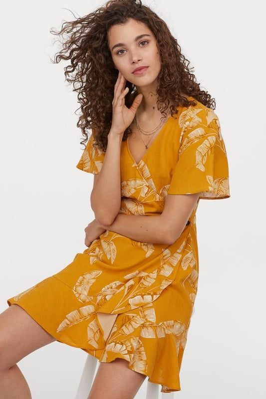 Vestido cruzado mostaza con hojas – Frescura tropical con toque chic