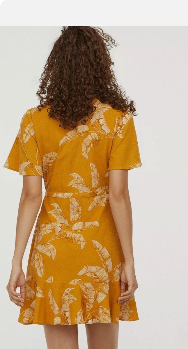 Vestido cruzado mostaza con hojas – Frescura tropical con toque chic